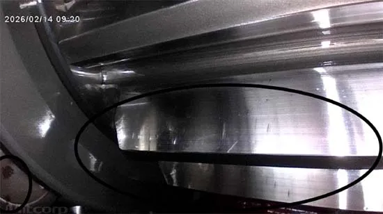 Figure 5. A dark, sharply defined transverse line on the gear teeth, with particle accumulation visible at lower left.