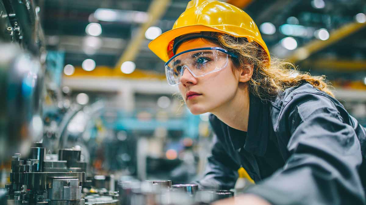 Maintenance technician wearing a hard hat and safety glasses in a manufacturing plant