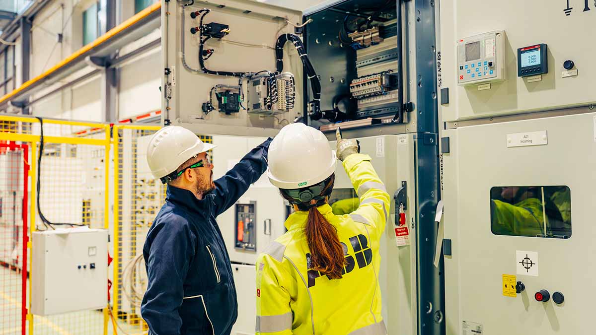 Engineers pointing at equipment in manufacturing plant